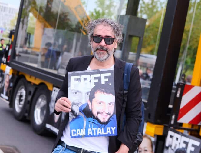 Deniz Yücel, journaliste turco-allemand et ancien prisonnier politique, demande la libération de l’avocat Can Atalay (en photo sur sa pancarte), le 7 mai 2022 à Berlin.